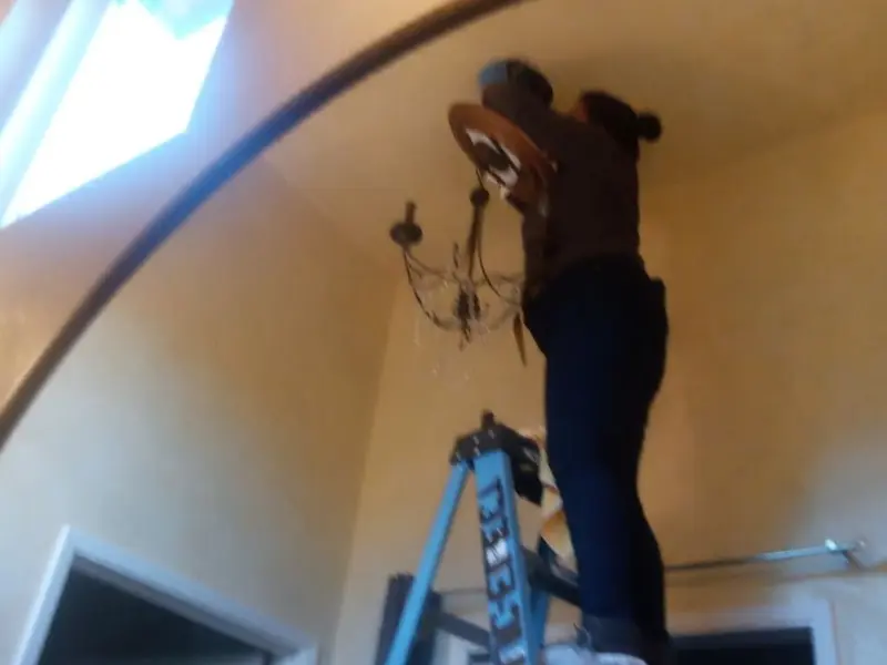 Electrician installing a chandelier in a West Menlo Park residence